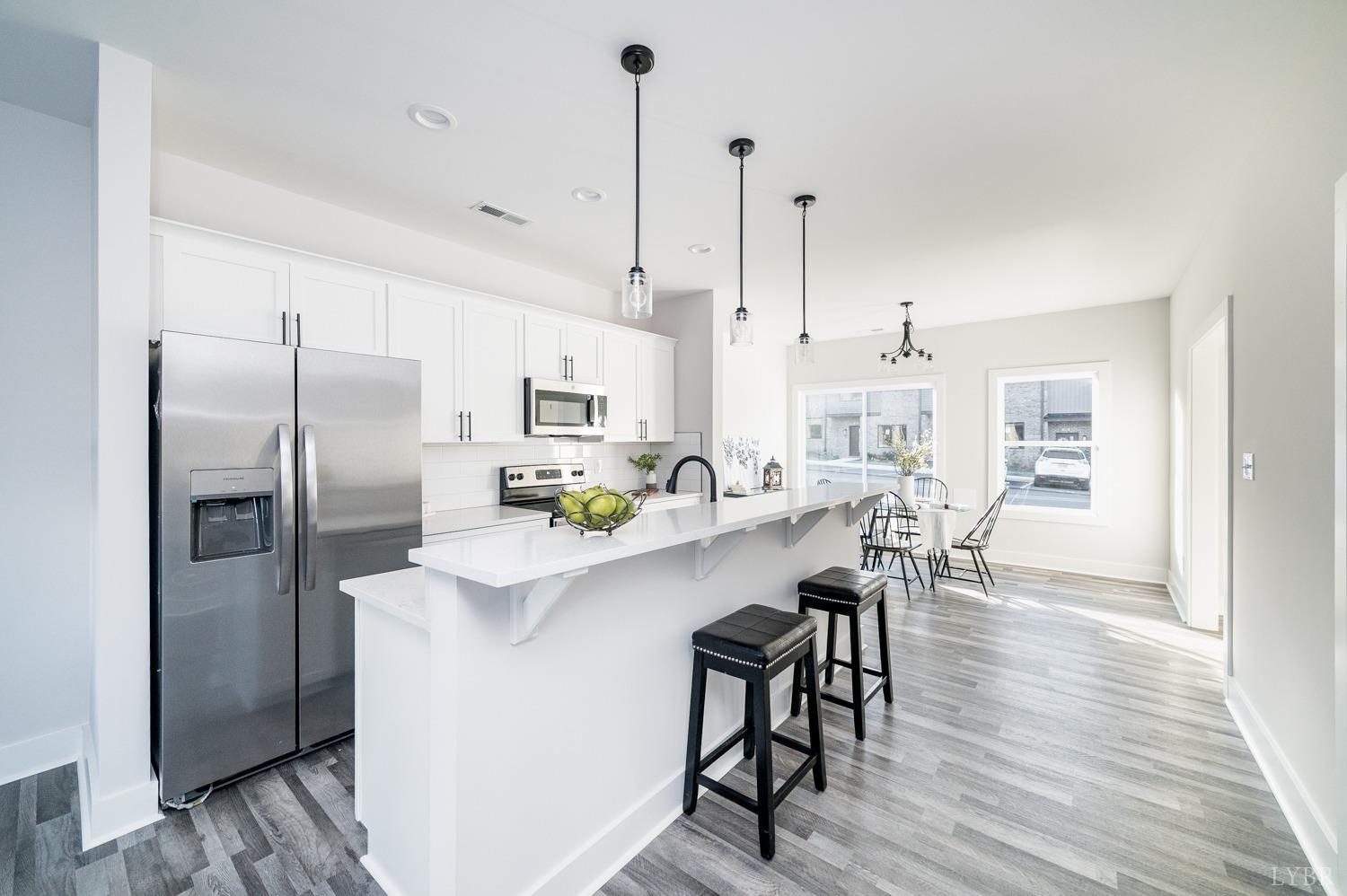 71 Allure Drive Rustburg, VA 24588 - Photo 18 of 56 a kitchen with stainless steel appliances a dining table chairs refrigerator and microwave