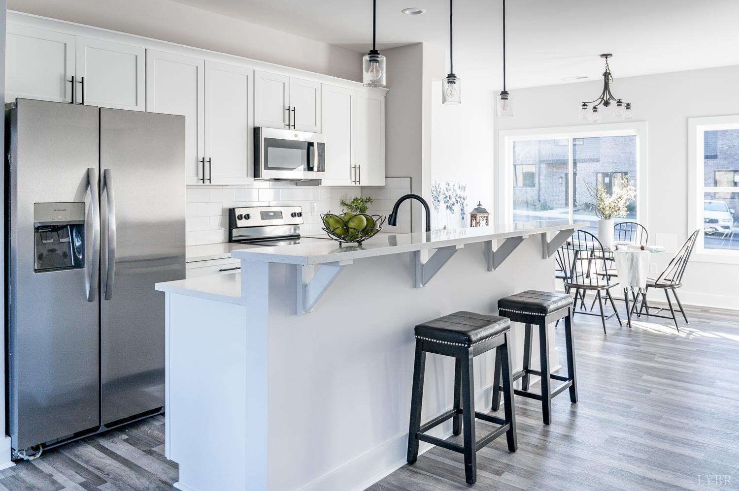 71 Allure Drive Rustburg, VA 24588 - Photo 50 of 56 a kitchen with stainless steel appliances a table chairs microwave and refrigerator