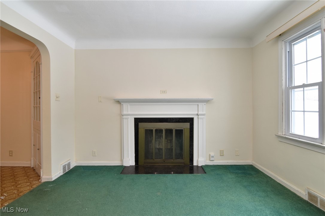 6308 Highland Road Cleveland, OH 44143 - Photo 7 of 40 Unfurnished living room with a fireplace with flush hearth, arched walkways, a wealth of natural light, and visible vents