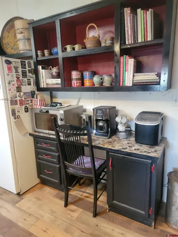a table chair in a kitchen and a book shelf