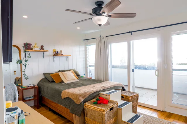 a view of a bedroom with a bed and wooden floor