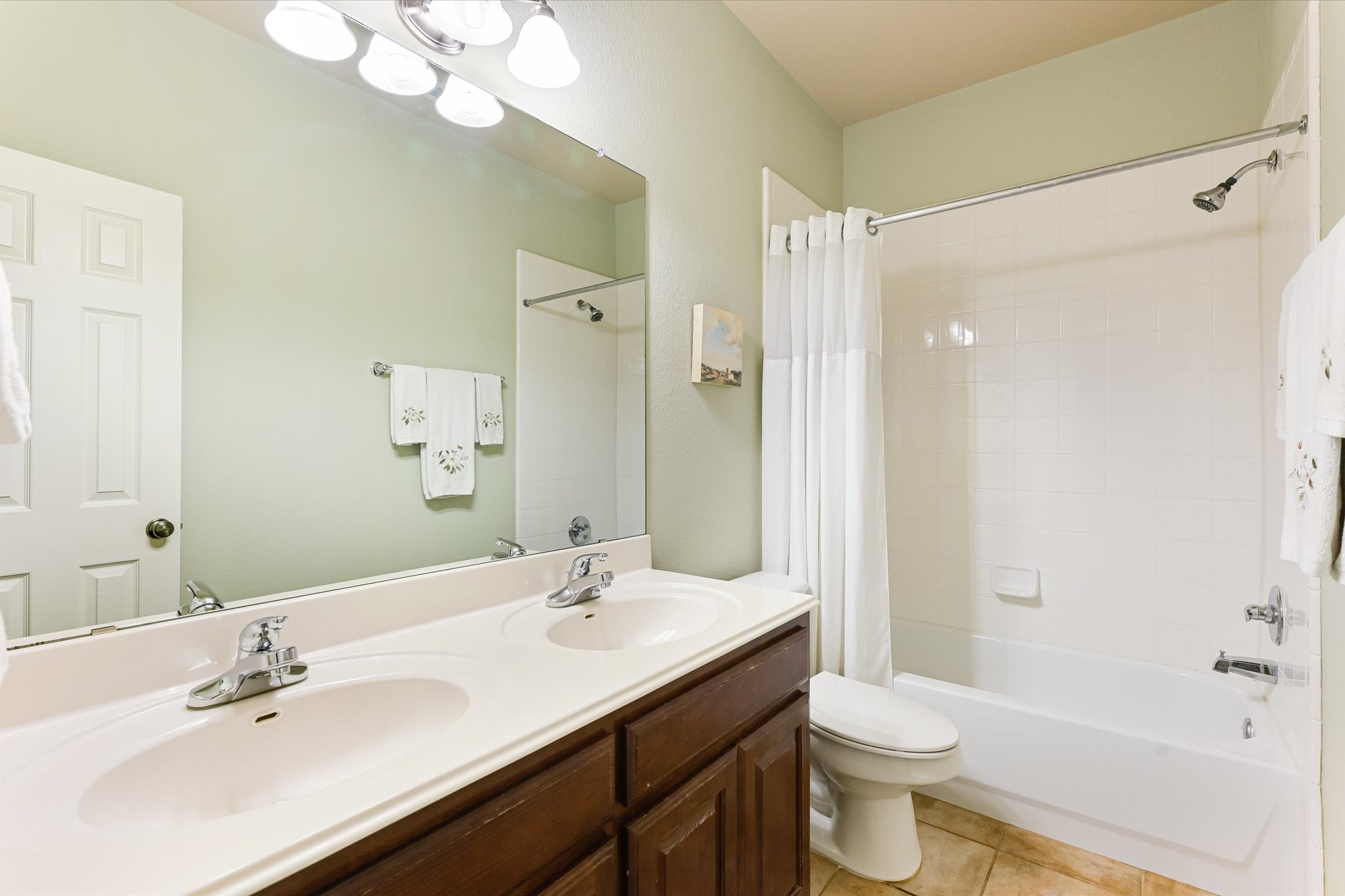 786 Ranchers Club Lane Driftwood, TX 78619 - Photo 21 of 33 Full bathroom featuring shower / bath combo with shower curtain, light tile patterned floors, and double vanity
