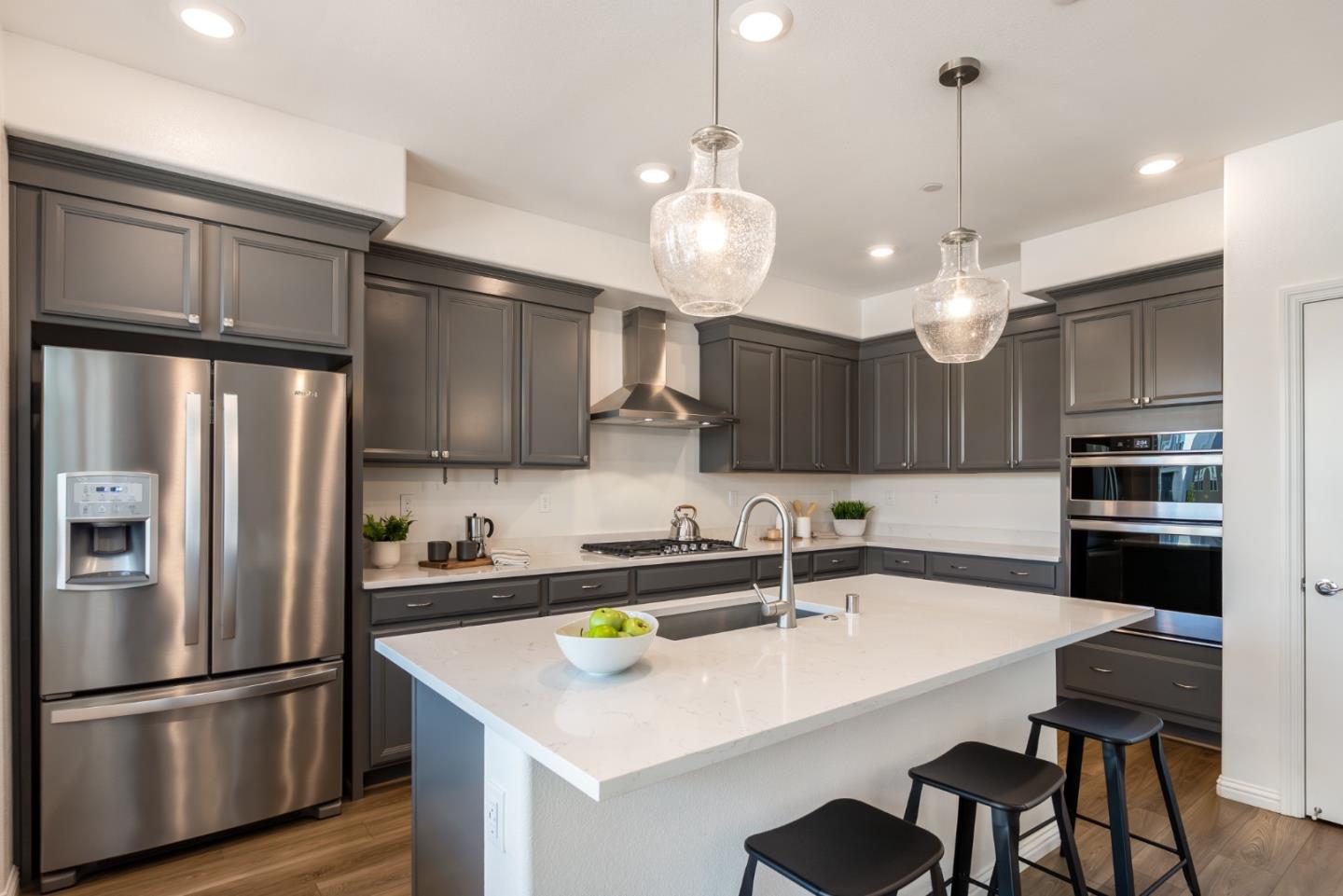 5724 Immersion Loop San Jose, CA 95119 - Photo 4 of 24 a kitchen with stainless steel appliances a table chairs refrigerator and microwave