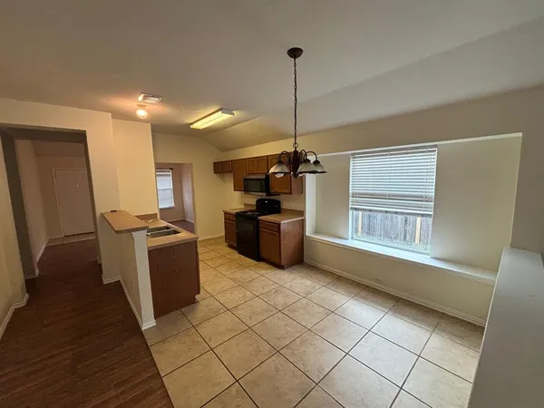 a view of a kitchen with fridge and windows