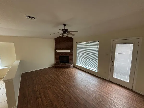 a view of empty room with wooden floor and fireplace