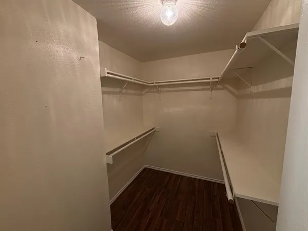 a view of walk in closet with empty racks