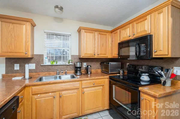 a kitchen with granite countertop a sink a window stainless steel appliances and cabinets
