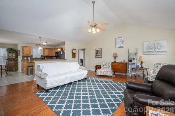 a living room with furniture a dining table and a chandelier