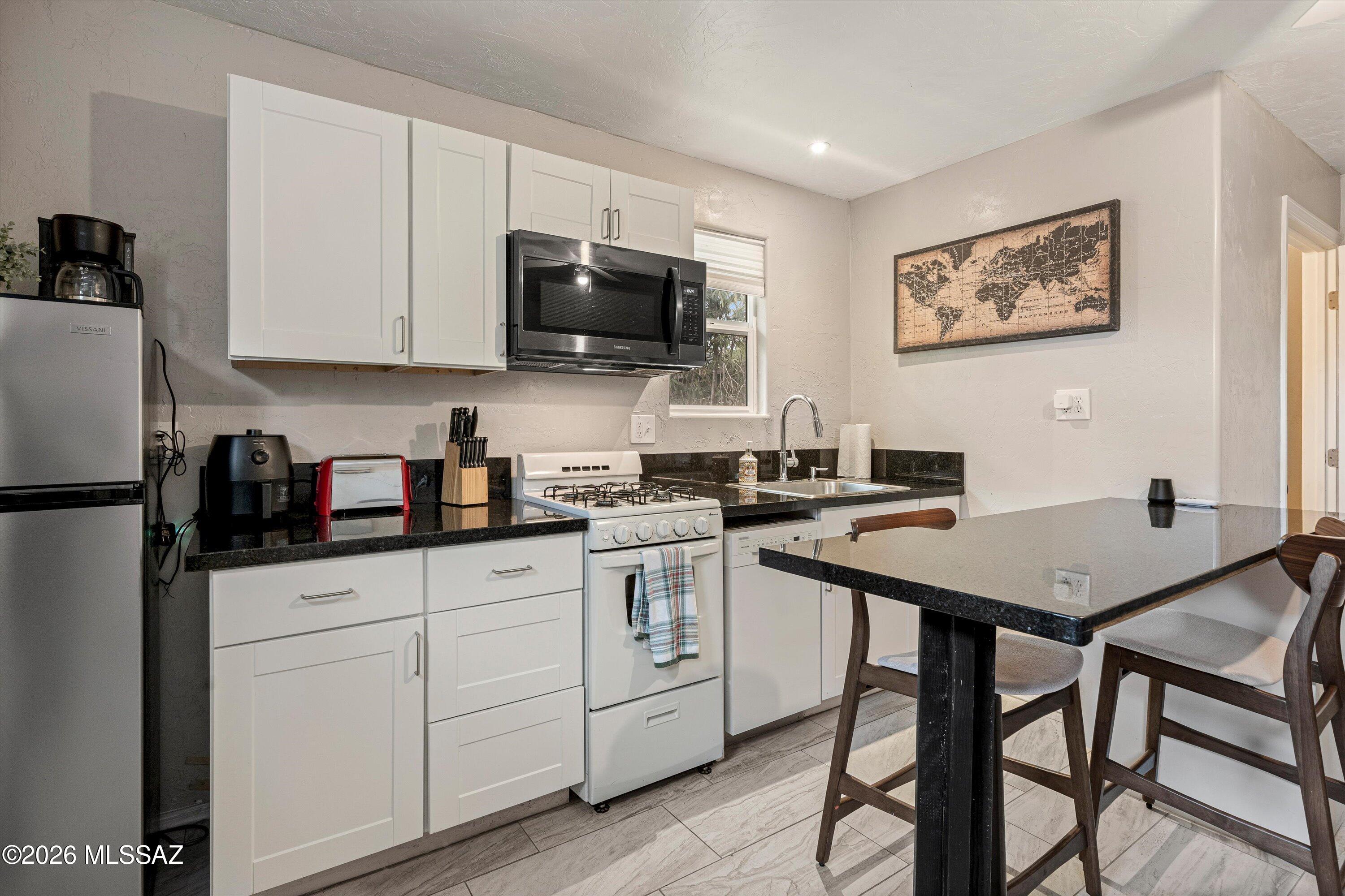 2841 North Richey Boulevard Tucson, AZ 85716 - Photo 29 of 30 a kitchen with stainless steel appliances granite countertop a stove a sink dishwasher and a refrigerator with wooden floor