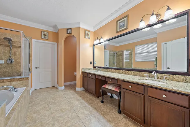 a spacious bathroom with a granite countertop sink mirror and a bathtub