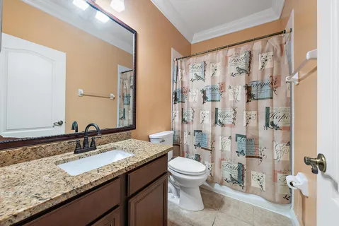a bathroom with a granite countertop sink toilet and shower