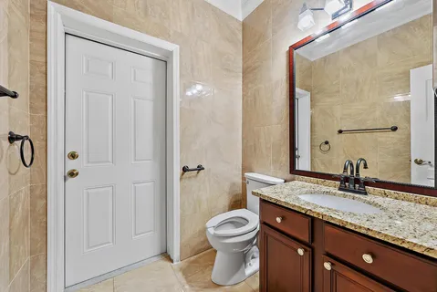 a bathroom with a granite countertop sink toilet and shower