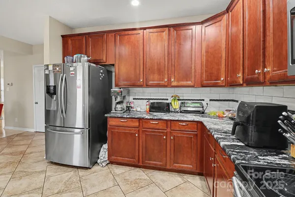 a kitchen with stainless steel appliances granite countertop a refrigerator stove and cabinets