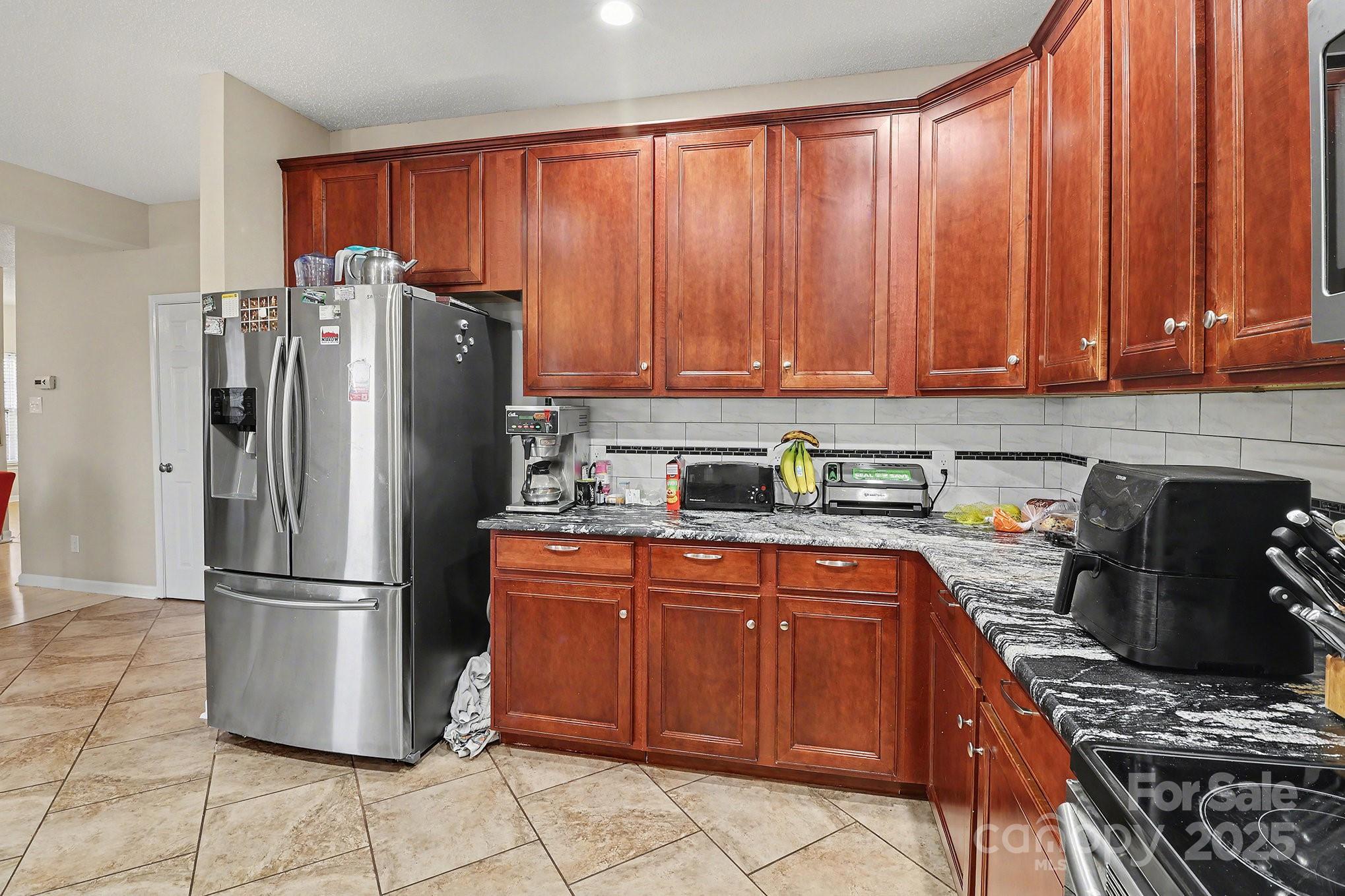5307 Bendix Court Harrisburg, NC 28075 - Photo 17 of 25 a kitchen with stainless steel appliances granite countertop a refrigerator stove and cabinets