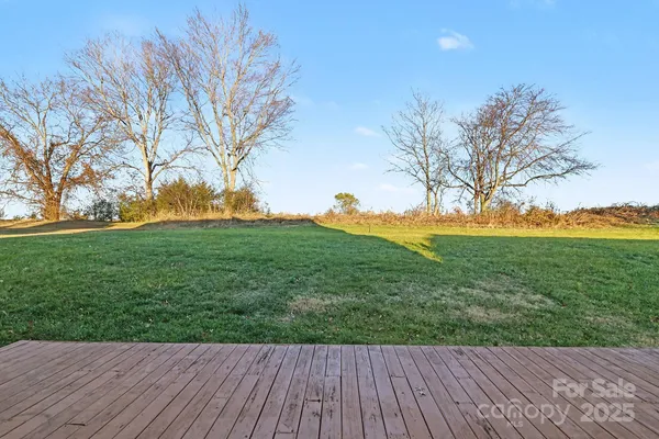 a view of backyard with wooden floor and fence