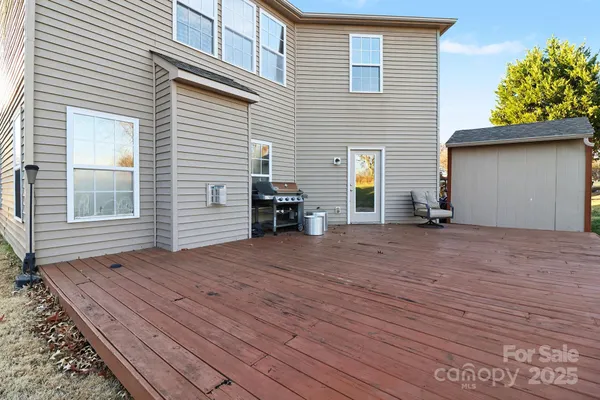 a view of house with backyard and deck