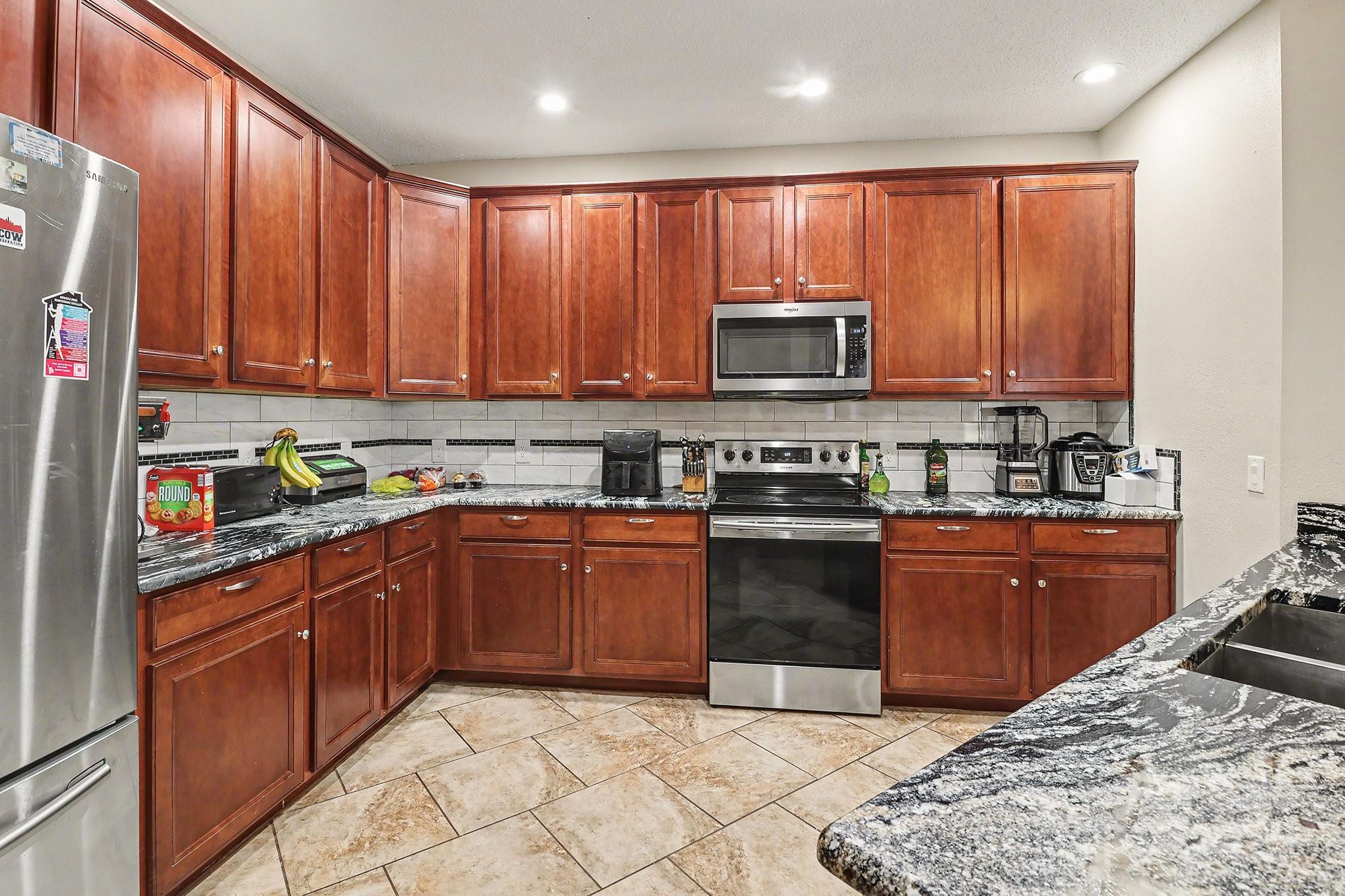 5307 Bendix Court Harrisburg, NC 28075 - Photo 3 of 25 a kitchen with stainless steel appliances granite countertop a stove top oven a sink dishwasher and a refrigerator with wooden cabinets