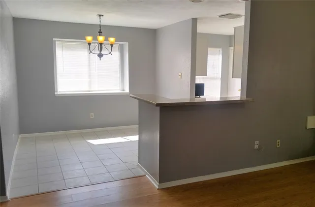 an empty room with wooden floor and window