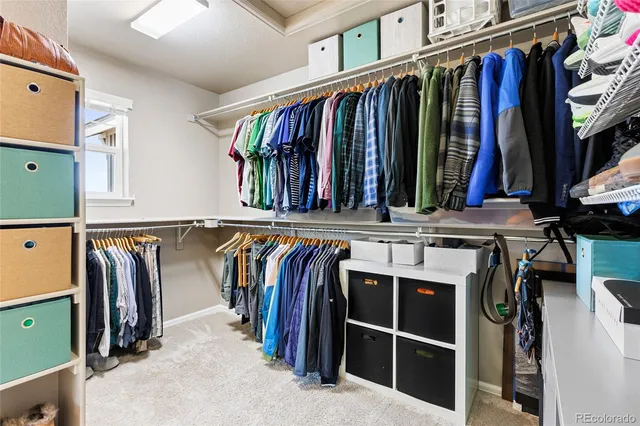 a view of walk in closet with clothes and shoes