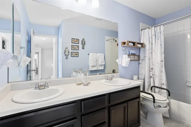 a bathroom with a double vanity sink toilet and shower