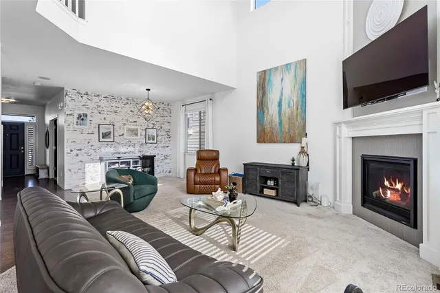 a living room with furniture a fireplace and a flat screen tv