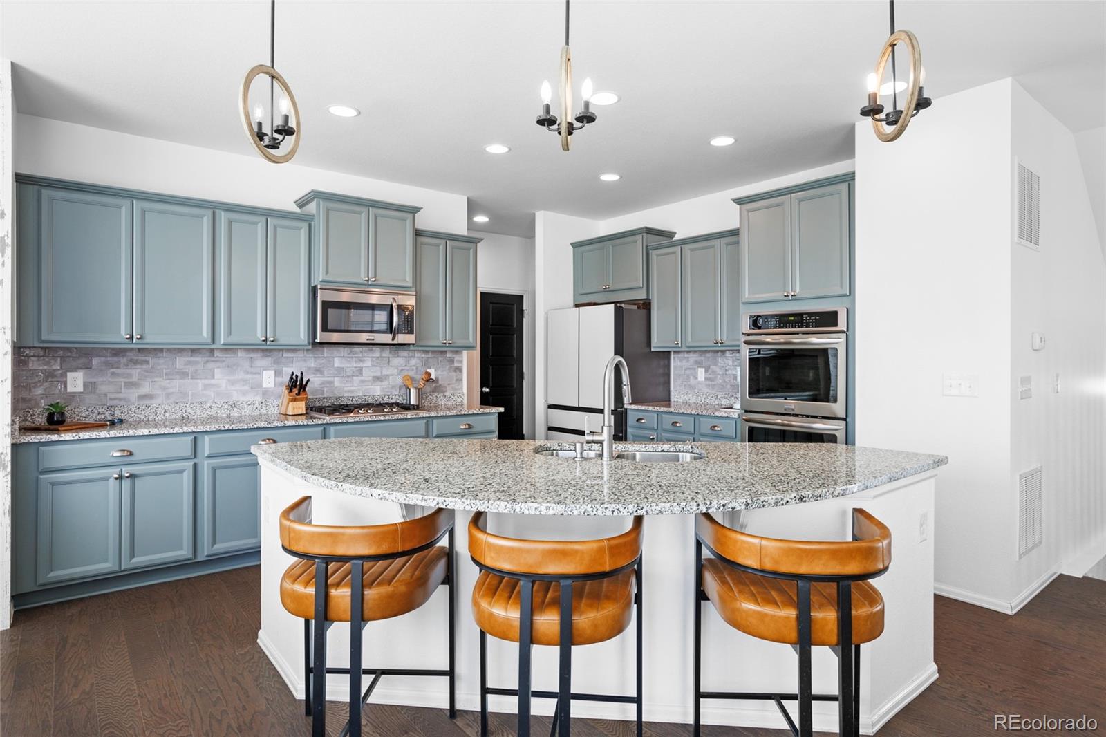1444 Sidewinder Circle Castle Rock, CO 80108 - Photo 5 of 40 a kitchen with stainless steel appliances granite countertop a sink and a refrigerator