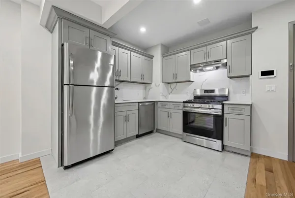 a kitchen with stainless steel appliances a refrigerator sink and white cabinets