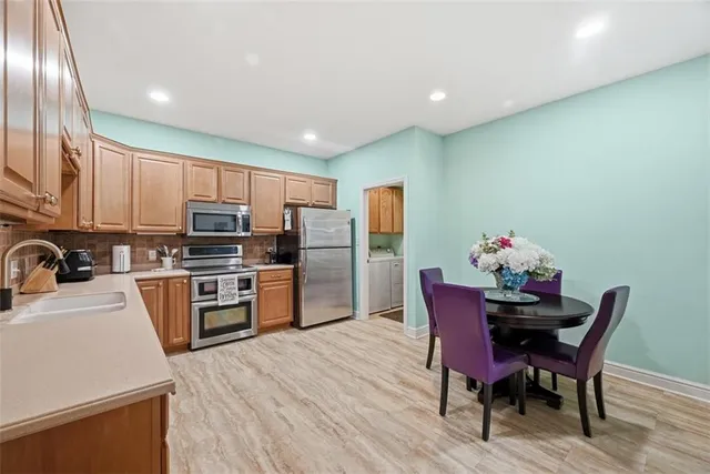 a kitchen with refrigerator a sink and chairs