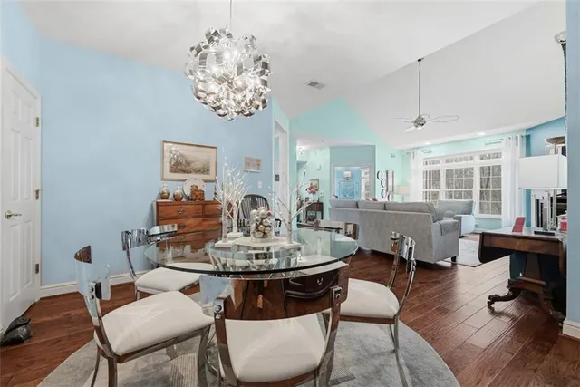 a view of a dining room with furniture a chandelier and wooden floor