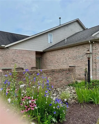 a front view of a house with lots of flowers