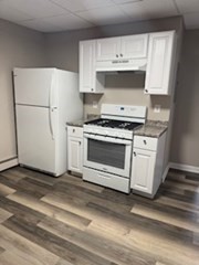 153 Union Street, Unit 1 Lawrence, MA 01841 - Photo 2 of 8 a white stove top oven sitting inside of a kitchen