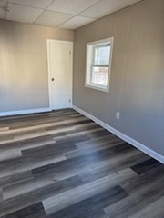 153 Union Street, Unit 1 Lawrence, MA 01841 - Photo 6 of 8 a view of an empty room with wooden floor and a window