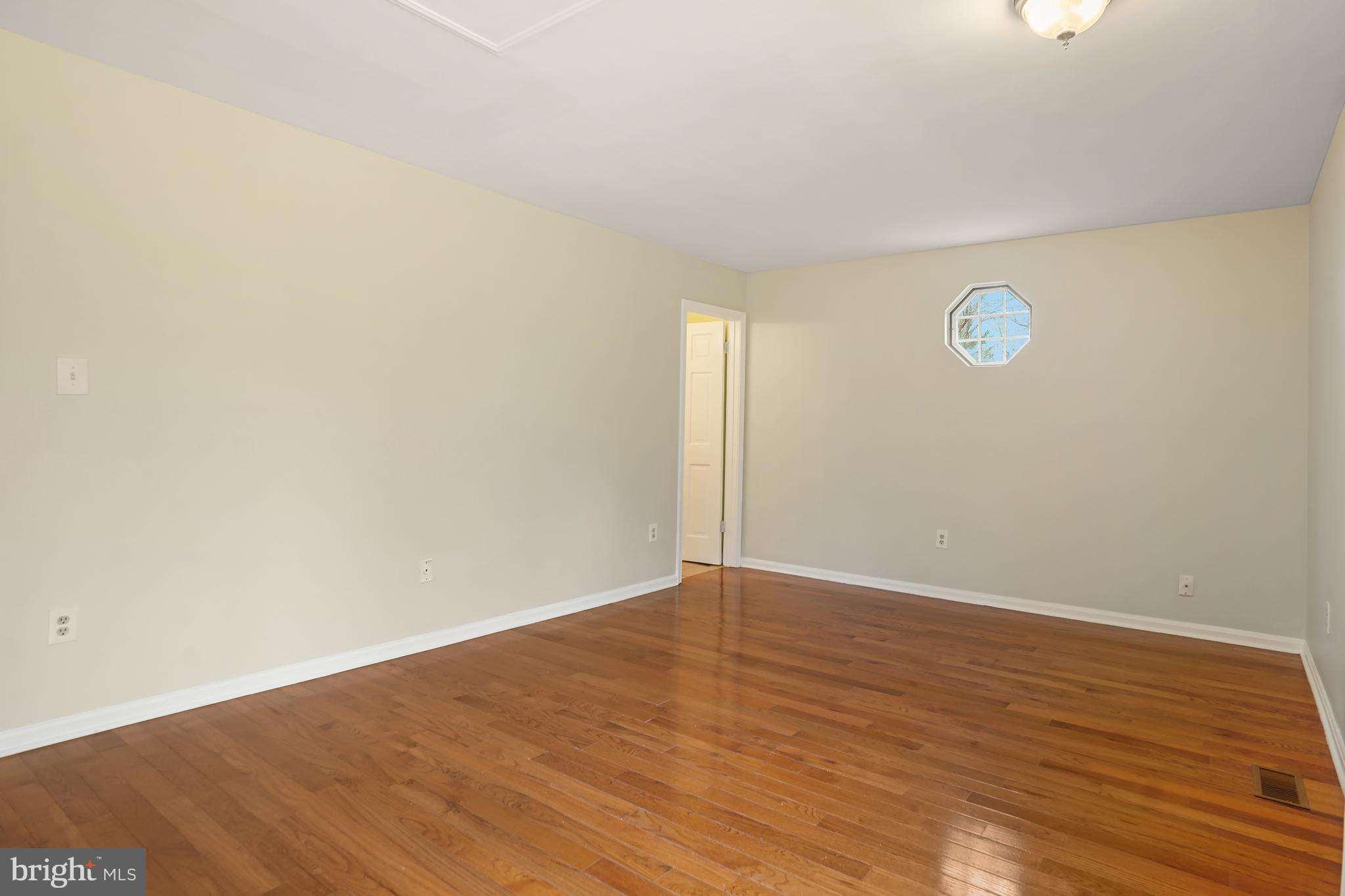 9412 Kilbride Court Perry Hall, MD 21128 - Photo 21 of 52 a view of an empty room with wooden floor and a window
