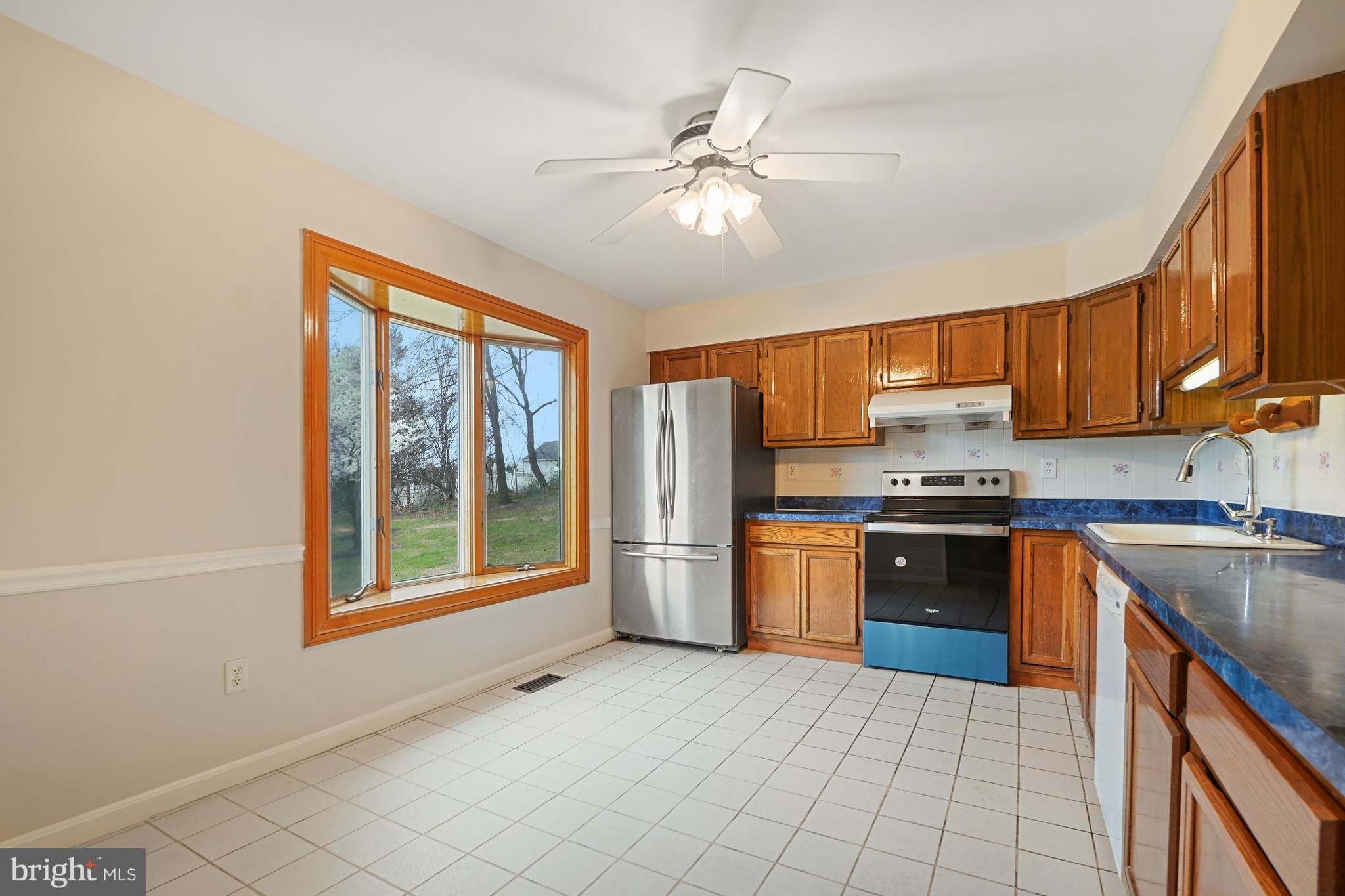 9412 Kilbride Court Perry Hall, MD 21128 - Photo 8 of 52 a kitchen with stainless steel appliances granite countertop a refrigerator a sink dishwasher a stove with wooden cabinets and floor