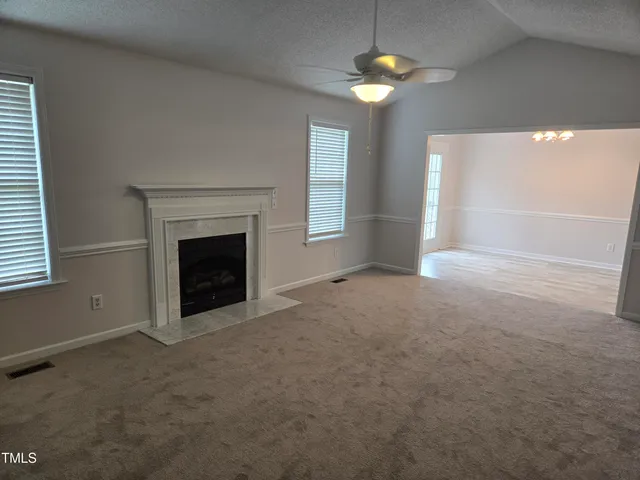 an empty room with a fireplace and fan