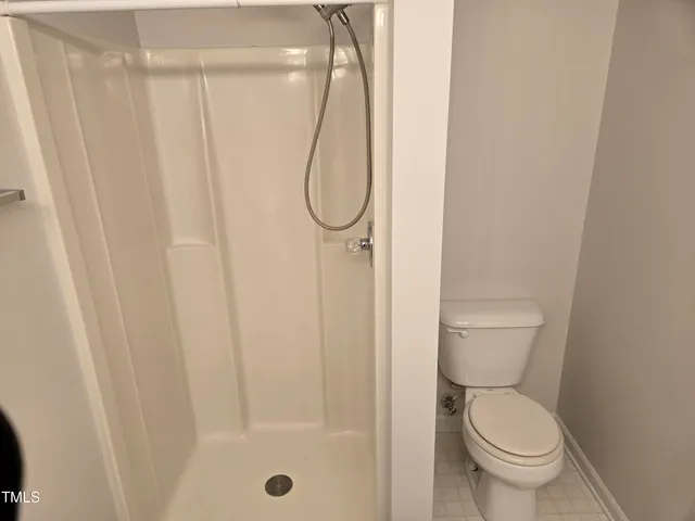 a bathroom with a granite countertop toilet and a shower
