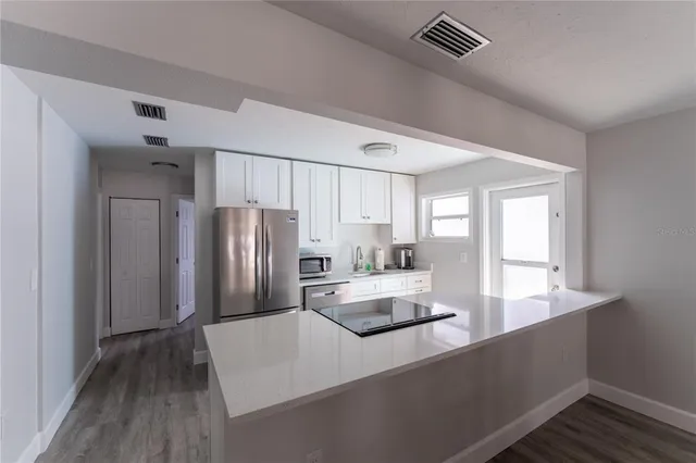 a large kitchen with kitchen island a sink stainless steel appliances and cabinets