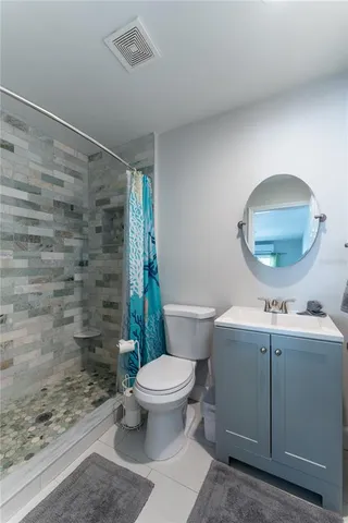 a bathroom with a sink a toilet a mirror and shower