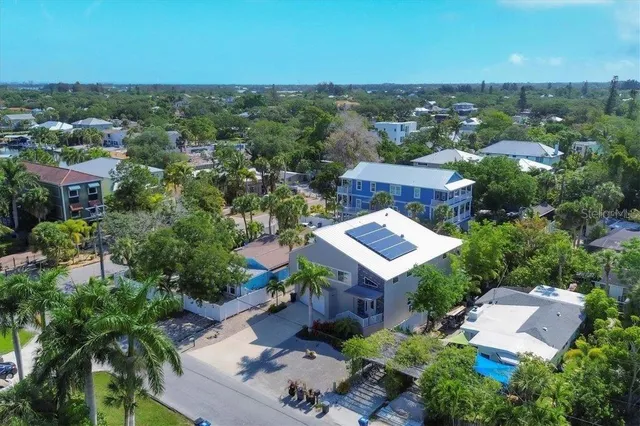 an aerial view of residential houses with outdoor space and trees