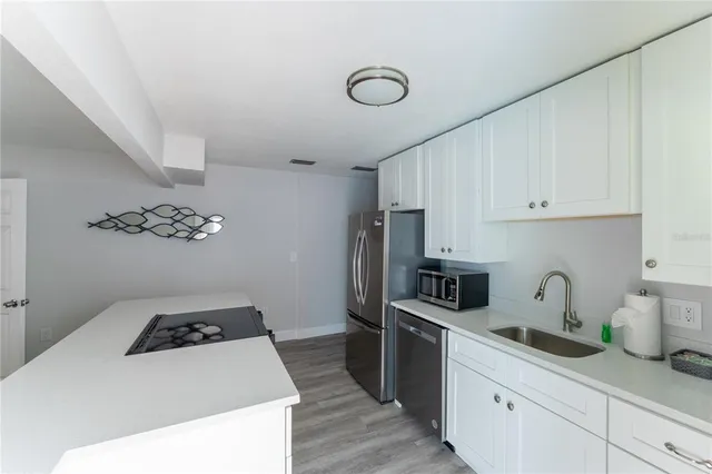 a kitchen with granite countertop a sink a stove and refrigerator