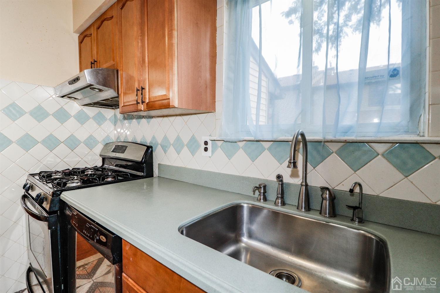 5602 Hana Road Edison, NJ 08817 - Photo 12 of 29 a kitchen with a sink a stove and a microwave oven