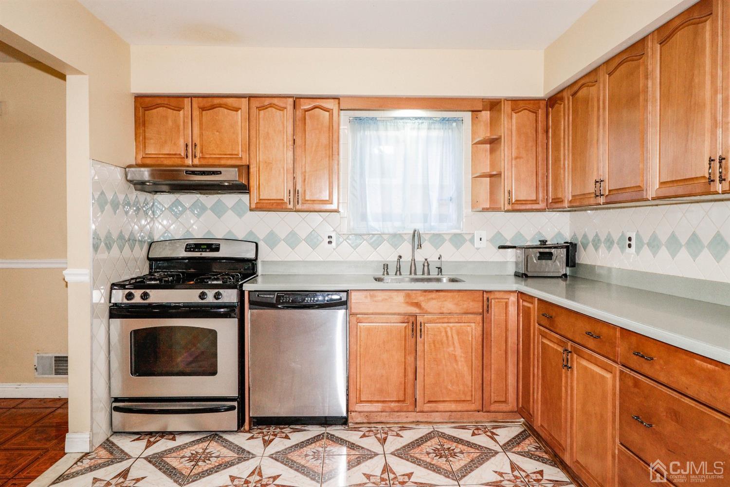 5602 Hana Road Edison, NJ 08817 - Photo 13 of 29 a kitchen with stainless steel appliances granite countertop a stove a sink and a microwave