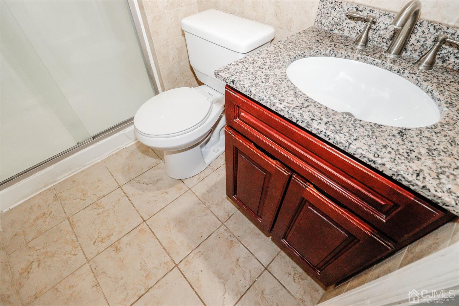 5602 Hana Road Edison, NJ 08817 - Photo 21 of 29 a bathroom with a granite countertop sink and a mirror