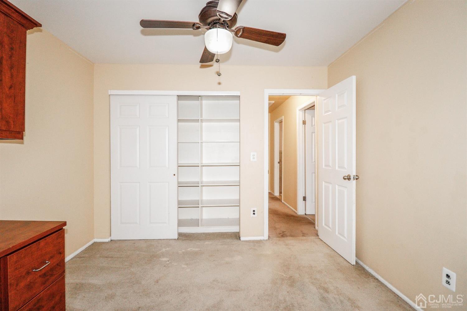 5602 Hana Road Edison, NJ 08817 - Photo 27 of 29 an empty room with closet and ceiling fan