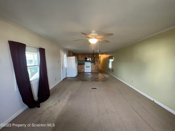 an empty room with a mirror and a ceiling fan