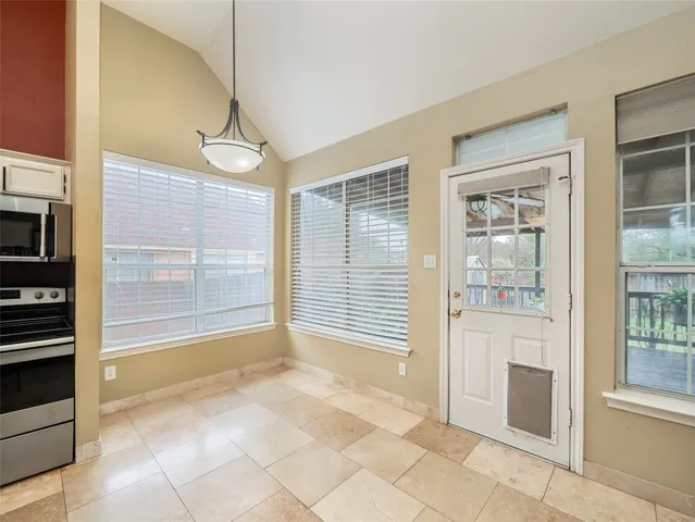 a view of an empty room with a fireplace and a window