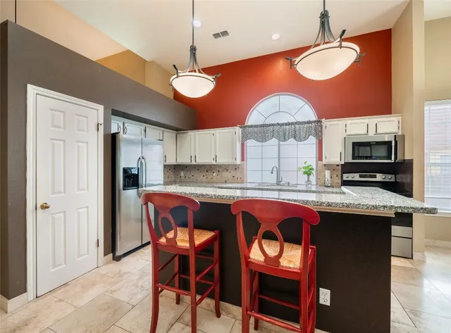 a kitchen with stainless steel appliances granite countertop a stove a sink and a refrigerator
