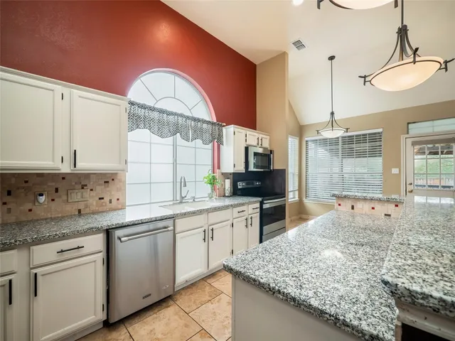 a kitchen with a sink stove and cabinets