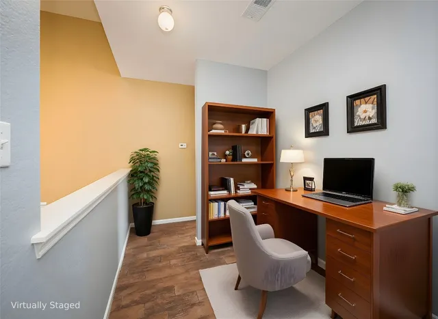 a view of a workspace with furniture and a window