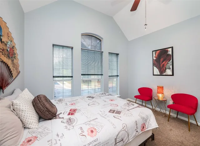 a bedroom with a bed a chandelier and a window
